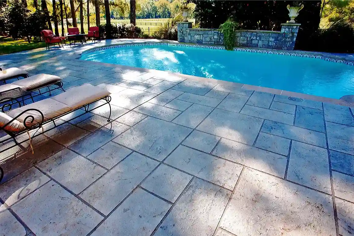 concrete pool deck with lounge chairs, creating a stylish outdoor space